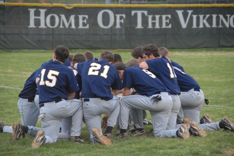 High School Athletes and Student Graduates Praying